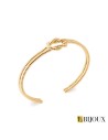 Bracelet jonc ouvert en plaqué or avec un nœud d'Héraclès symbole de force et de liens forts.